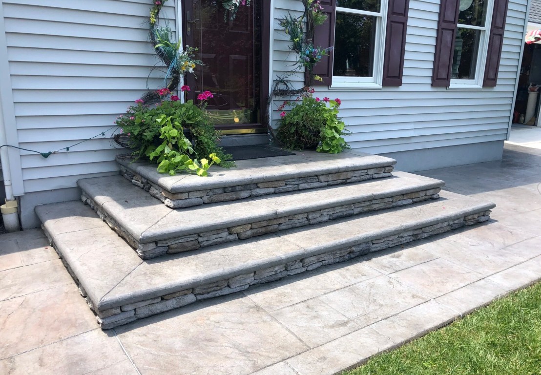 Elegant tiered concrete steps with decorative stone veneer risers and landscaping in Leavenworth, KS